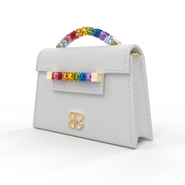 Front side angle view of white Rainbow Baby Jewel Crossbody showing a slender, collapsible side profile. Emerald-cut Swarovski crystals are flush together at their edges, forming a rainbow gradient with square-shaped yellow gold hardware end caps.
