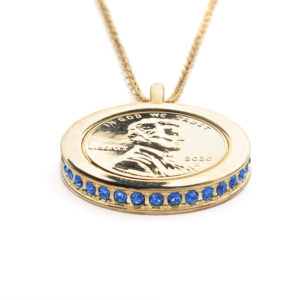 The Skyla, Wear to Evoke Loyalty pendant and necklace with plated US penny set into a 22 carat band edged with sparkling Sapphire Blue-Swarovski crystals.